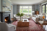 Living room with red rug, fireplace, sofa, chairs, and decorative items.