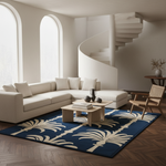 A modern living room featuring a large navy blue area rug with a cream palm tree pattern, styled with a cream sectional sofa, wooden coffee table, and a spiral staircase in the background.