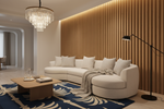 A modern curved cream sectional sofa in a styled living room with a slatted wood accent wall, a blue patterned rug, a wooden coffee table, and a black floor lamp.