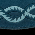 Close-up of a textured blue rug featuring a raised, woven geometric pattern in a contrasting light blue and white, set against a solid black background.