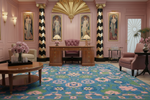 Luxurious interior with pink walls, decorative columns, and a patterned rug.