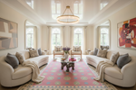 Living room with beige sofas, a pink rug, and decorative elements.