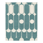Teal and white geometric patterned rug on a plain background