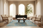 Modern living room with a blue rug, white walls, and neutral decor.