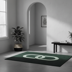 Green rug with a white logo in a modern room with plants and a table.