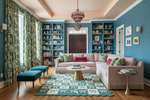 Living room with blue walls, a pink sofa, and decorative rug.