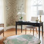 Living room with a desk, chairs, and a decorative rug.