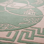 Close-up of a textured rug with a traditional Chinese-inspired design, featuring a pale sage green and light pink color scheme with embossed cloud and pagoda motifs.