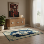 A rectangular area rug with a navy blue central field and cream border, styled on a light wood floor in a modern living room next to a window with white curtains.