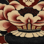Close-up of a plush area rug featuring a traditional Japanese-style floral motif with cream petals, deep red accents, and a black base.