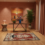 A styled interior scene showing a rectangular area rug with a red, beige, and black traditional pattern on a light wood floor. A wooden console table with black metal legs sits in the center, decorated with flowers and a blue vase, in front of a two-panel sunset wall art.