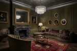 Luxurious living room with red floral chinoiserie rug, dark green walls, a fireplace, and elegant furniture.