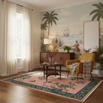 A styled interior room with a large vintage-style mural depicting palm trees and sailing ships on the wall. A mustard yellow armchair with a patterned throw sits on a pink and green patterned area rug beside a round wooden coffee table and a dark wood sideboard. Sheer white curtains hang by the window, and a tall floor mirror stands against the wall.