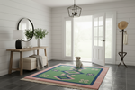 Dog sitting on a colorful rug in a room with a wooden table, mirror, and door.