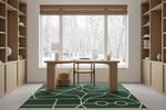 Modern home office with wooden desk, green rug, bookshelves, and a large window view