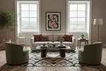 Modern living room with a beige sofa, green chairs, and a patterned rug.