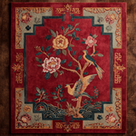 Decorative rug with floral and bird design on a red background