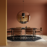 A modern dining room setup featuring a dark rectangular table surrounded by four brown upholstered chairs with chrome legs, set on a black and white patterned rug. A large round mirror on the terracotta-colored wall reflects a black pendant light. The room has light wood flooring and a warm terracotta wall.