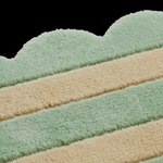 Close-up of a plush, textured fabric product with horizontal stripes in sage green and warm beige, set against a solid black background.
