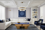 Modern living room with white sofa, blue coffee table, and decorative geometric rug, wall art.