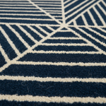 Close-up of a textured area rug with a geometric pattern in navy blue and cream.