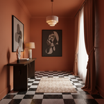 A styled interior room with terracotta walls, a black-and-white checkered floor, a beige patterned rug, a white pendant light, a dark wood console table with framed wall art, and draped curtains by a window.