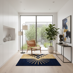 A modern living room interior with a navy and mustard yellow geometric area rug on light wood flooring. The room features a brown leather armchair, a black floor lamp, a potted fiddle-leaf fig plant, a white console table with a framed abstract print, and a large glass window looking out onto green garden foliage.
