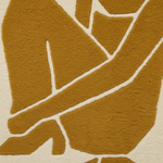 A close-up of a textured fabric or rug pattern featuring a stylized abstract figure in mustard yellow with cream-colored outlines on a light beige background.