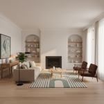 A beautifully styled modern living room featuring a beige sofa, a striped green and white area rug, a round wooden coffee table, two mid-century modern brown armchairs, and a black fireplace set within white walls with built-in wooden shelves.