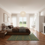 A beautifully styled modern bedroom featuring a low wooden platform bed with brown and white bedding, a green geometric patterned area rug, a large window with sheer curtains, and a hanging egg chair.