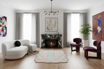 Modern living room with white sofa, purple chairs, and a fireplace.