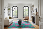 Living room with a colorful green rug, white sofa, and wooden chair.