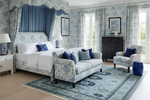 Luxurious bedroom with blue traditional persian floral rug, wallpaper, furniture, and decor.
