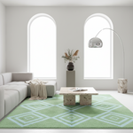 A modern living room scene featuring a light green and white geometric patterned area rug under a marble coffee table, with a light gray sectional sofa, arched windows, and a silver floor lamp.