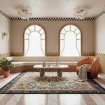 A beautifully styled bohemian living room featuring a large floral patterned area rug, a curved orange armchair with a knit throw, and a low marble coffee table. The room has two tall arched windows with gold-trimmed frames, a checkered border on the beige walls, and a checkered marble floor.