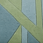 A close-up of a textured fabric or rug with a geometric pattern of intersecting diagonal and vertical stripes in muted sage green and dusty blue-gray.
