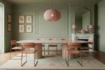 green dining room with green pink knotted rug and marble dining table.