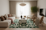 Living room with a patterned green rug, sofa, and decorative items.