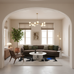 A modern living room interior with a curved brown sofa, round white marble coffee table, black and blue abstract rug, a potted plant, and warm neutral decor under an arched doorway.