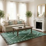 A green and white patterned area rug with fringe, styled in a bright living room with a beige sofa, wooden coffee table, and a white fireplace.