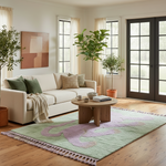Living room with a white sofa, wooden coffee table, and decorative green shaggy rug.