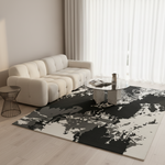 A modern living room scene featuring a large abstract area rug with a black, gray, and off-white pattern, styled under a cream tufted sofa and a glass-top coffee table.