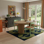 Dining room with a round wooden table and green chairs on a patterned rug.