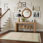 Narrow wooden console table with runner rug, decorative items in a home interior setting.
