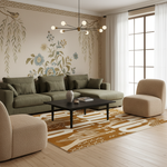 A styled living room featuring a sage green sectional sofa, a matching accent chair, a beige armchair, a black coffee table, and a patterned mustard and cream rug. The background showcases a beige wall with botanical and bird illustrations, a Greek key border, and a modern multi-arm chandelier.