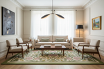 A beautifully styled living room featuring a cream-colored sofa, two matching armchairs, a wooden coffee table, and a large green and pink floral area rug. The room has elegant cream walls with white wainscoting, a modern black and gold pendant light, and framed abstract and landscape art.