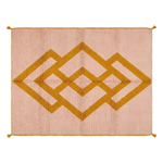 A rectangular woven rug with a dusty pink background and a large mustard yellow geometric diamond pattern, finished with small tassels at the corners.