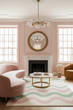Living room with pink walls, a fireplace, and a wavy patterned rug.