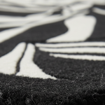 Close-up of a black and white abstract patterned rug showing the textured pile and contrasting fibers.