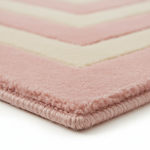Close-up of a plush area rug corner showing a dusty pink and cream chevron pattern with a thick braided border.